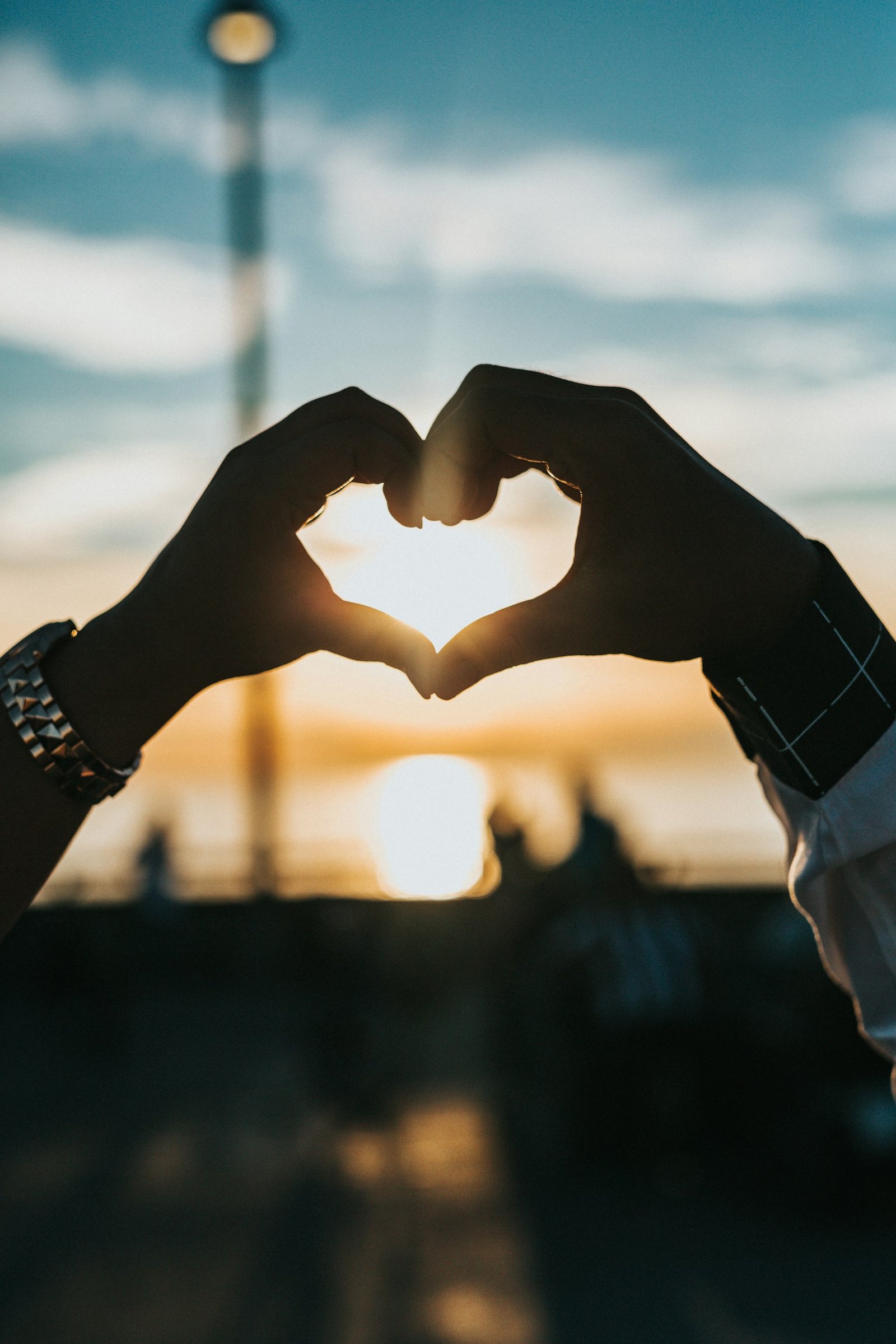 Two hands forming a heart in the golden evening light